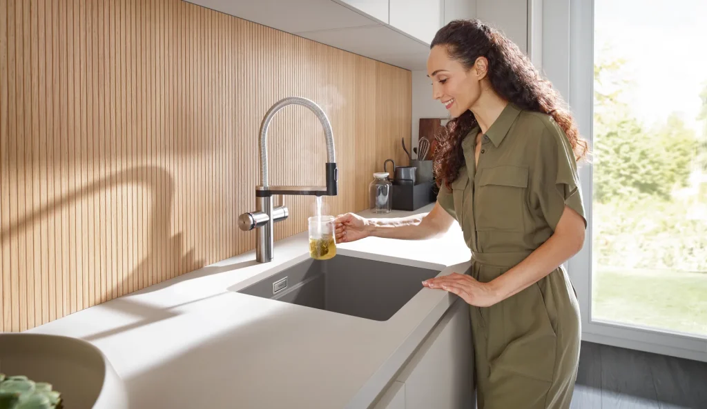 woman using sink in kitchen
